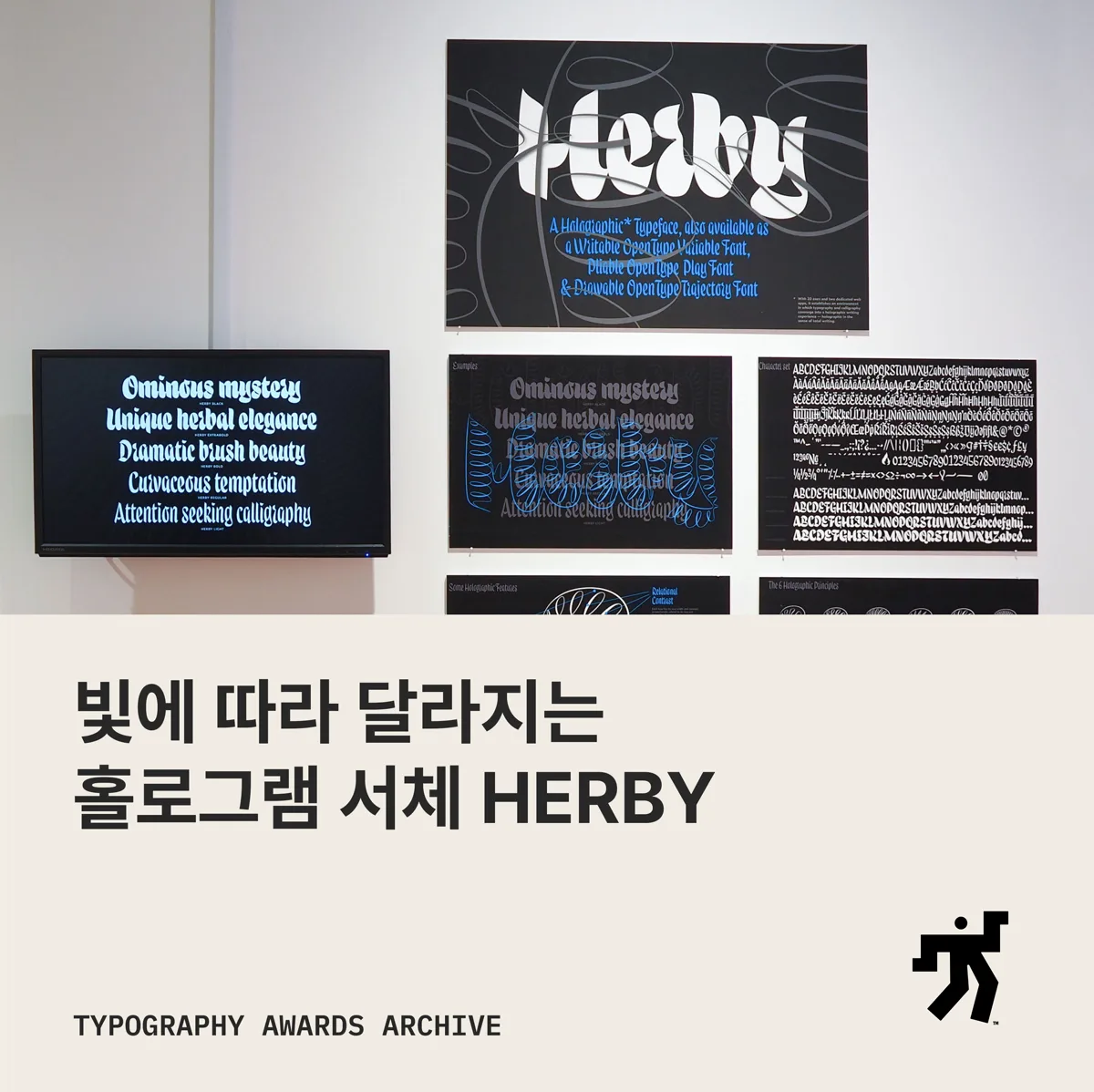 어두운 전시 벽의 Herby 견본 판 사진과 빛에 따라 달라지는 홀로그램 서체 HERBY 라는 제목이 놓인 카드