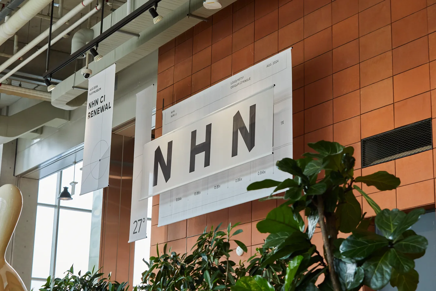 벽돌 벽에 걸린 NHN CI RENEWAL 27° 배너